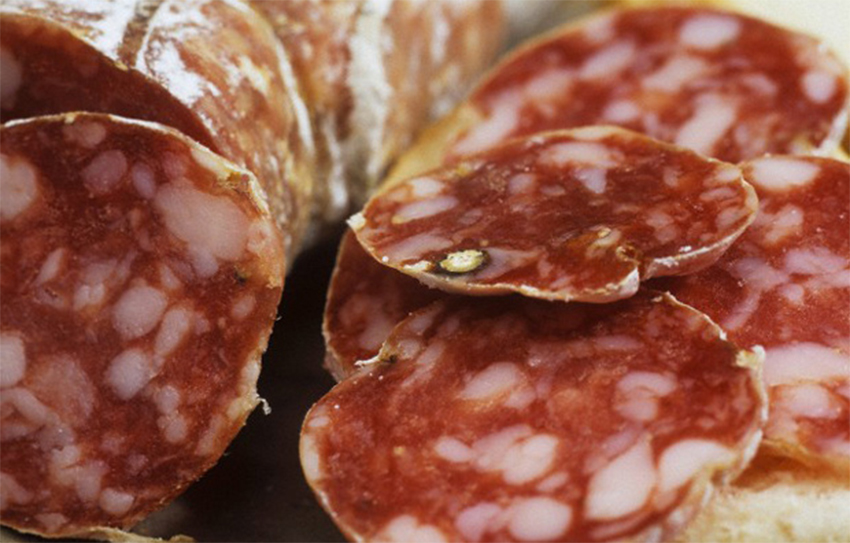 un parásito transmitido por alimentos que se encuentra en carne de cerdo cocida es